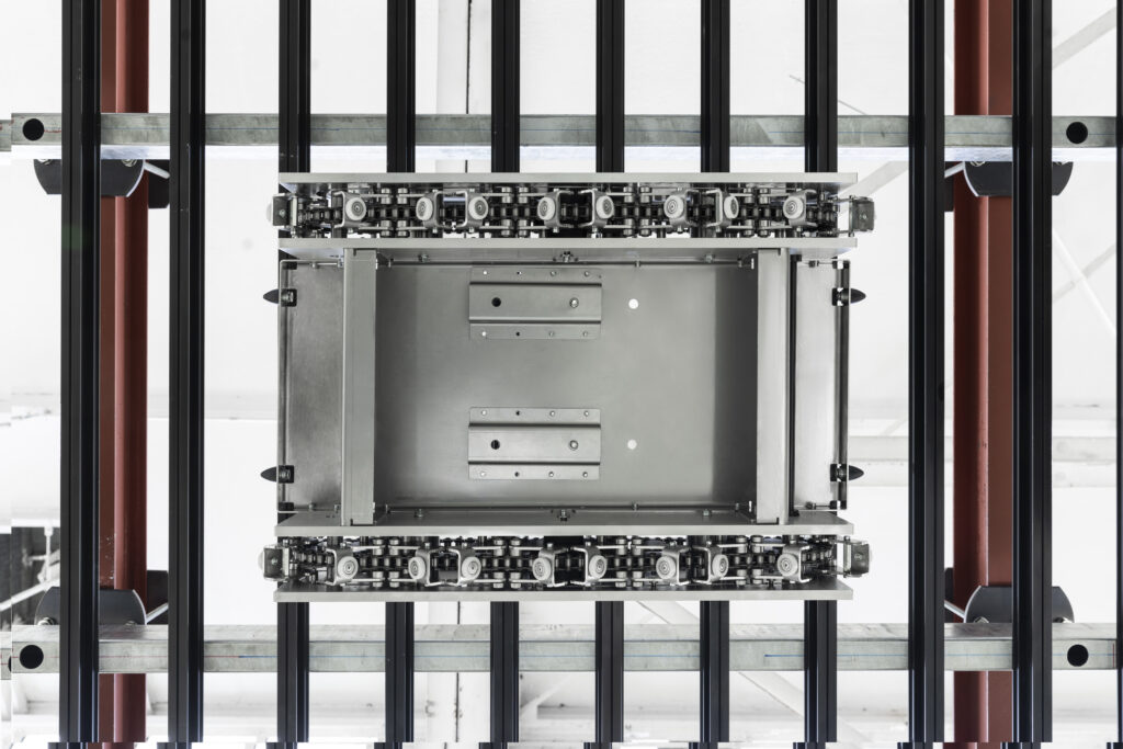 View from below of a CeiliX overhead shuttle module featuring chain-driven rails for high-speed storage and retrieval—an advanced automation solution for efficient intralogistics.