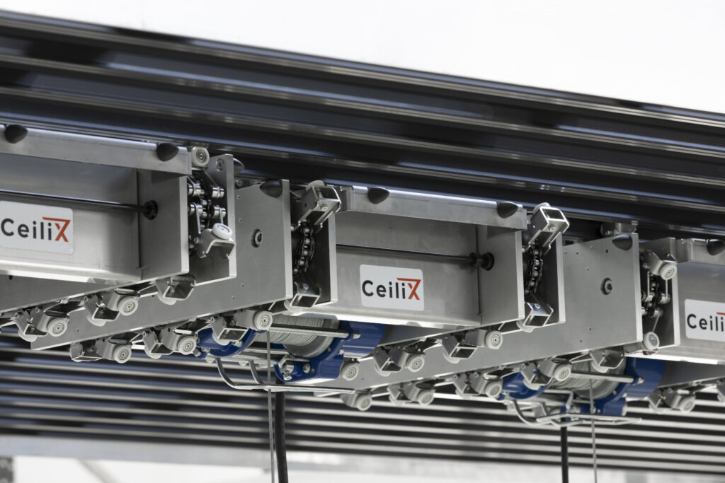 Close-up view of CeiliX overhead shuttle modules featuring chain-driven rails for precise and efficient intralogistics—an advanced warehouse automation solution.