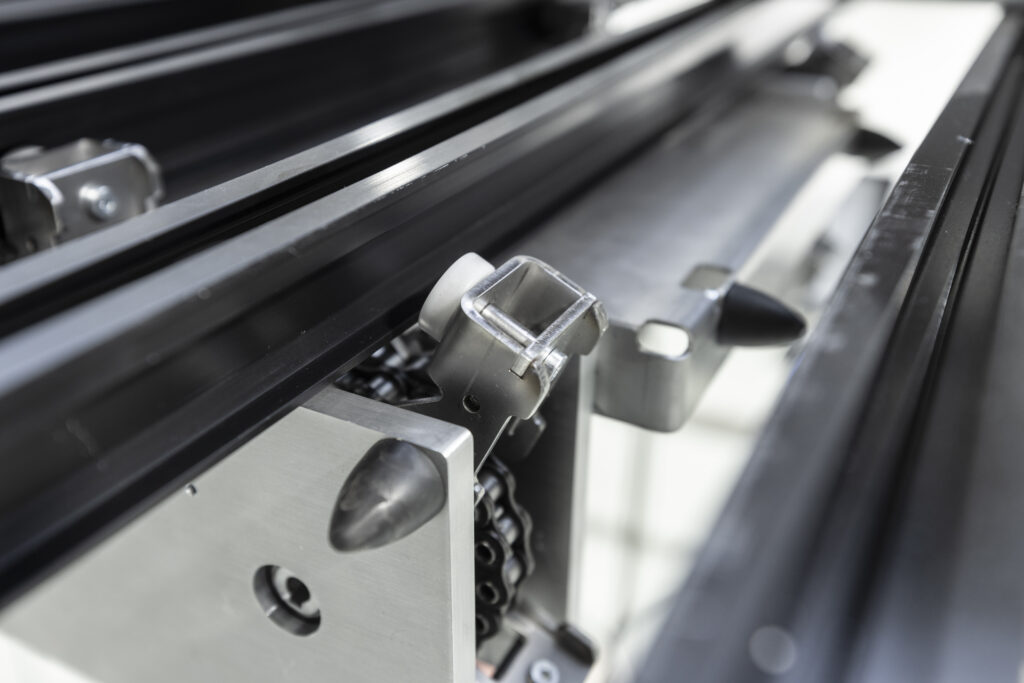 Close-up of the CeiliX overhead shuttle’s chain-driven guide bracket for precise and reliable intralogistics automation—an advanced solution for efficient warehouse operations.